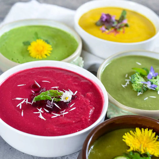 Bunte Gemüsesuppen mit Roter Bete, Brokkoli, Wildkräutern und essbaren Blüten für eine gesunde Küche.