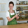 Eine Holzbürste wird in einer Edelstahlpfanne verwendet, um die richtige Reinigung und Pflege der Pfanne zu demonstrieren.
