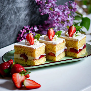 Luftige vegane Erdbeer-Vanille-Schnitten mit Creme und frischen Erdbeeren, liebevoll angerichtet auf Teller.