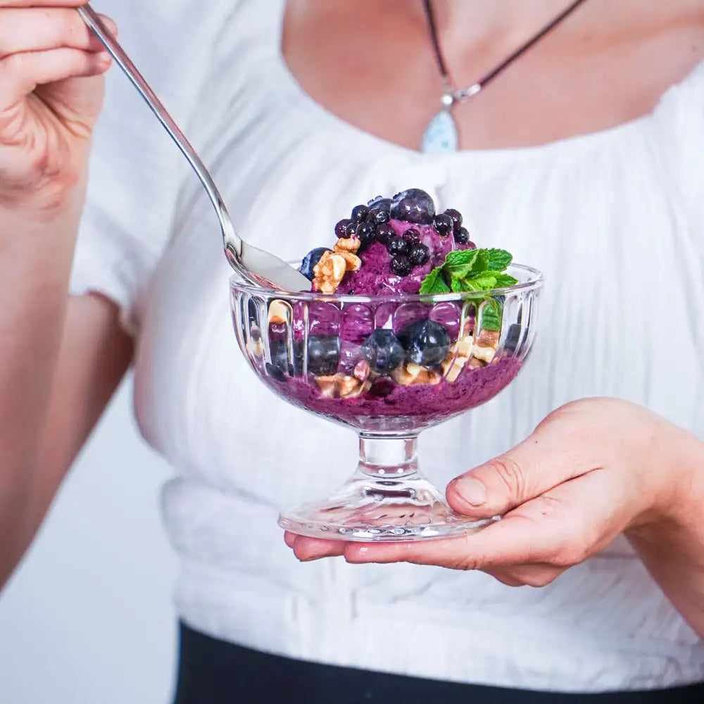 Cremige Heidelbeer-Nicecream mit frischen Beeren, Walnüssen und Minze als gesundes veganes Sommerdessert der Longevity-Küche.