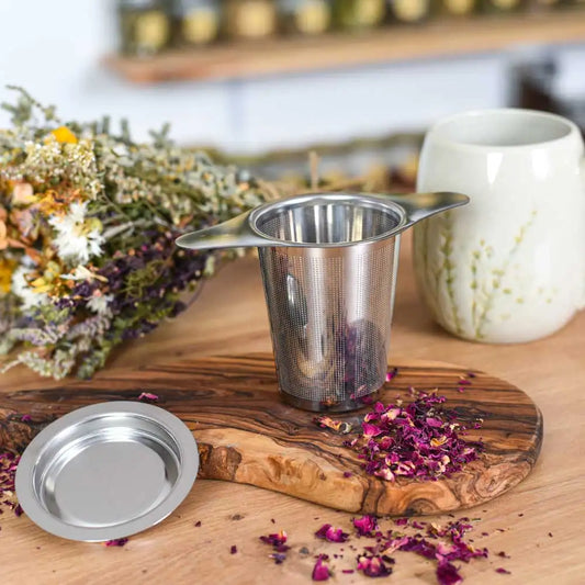 Edelstahl-Teesieb mit getrockneten Rosenblüten für die Zubereitung von losem Kräutertee.