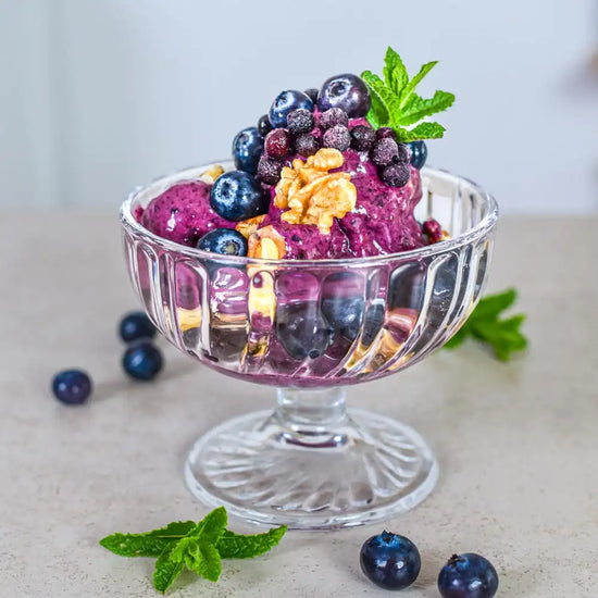 Cremiges veganes Heidelbeer-Eis mit frischen Beeren, Walnüssen und Minze als gesunde sommerliche Nachspeise der Longevity-Küche.